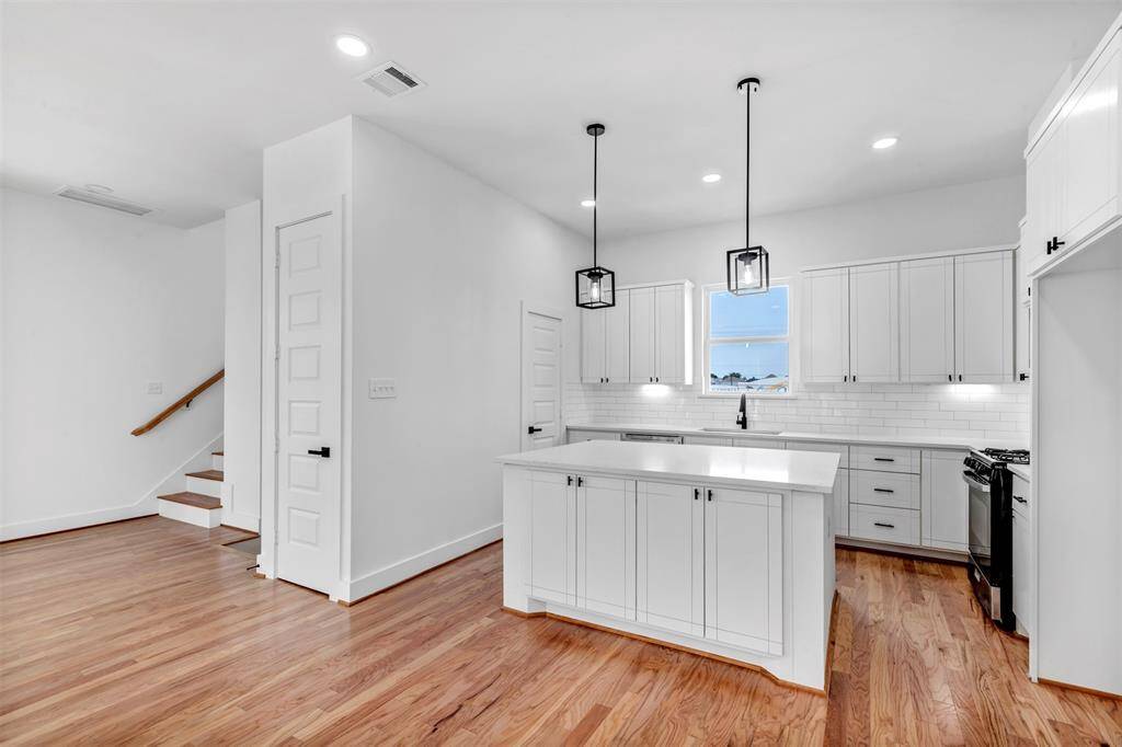 Complete with sleek stainless steel appliances and ample kitchen cabinets for storage, this space combines functionality with modern style.