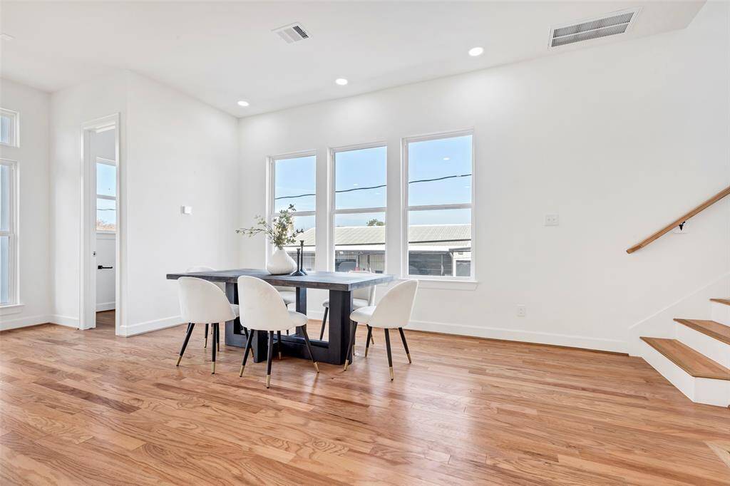Another view of the dining area, featuring a convenient half bath tucked away in the corner for added functionality. (Model unit at 1234 E 23rd St. Design and finishes may vary)