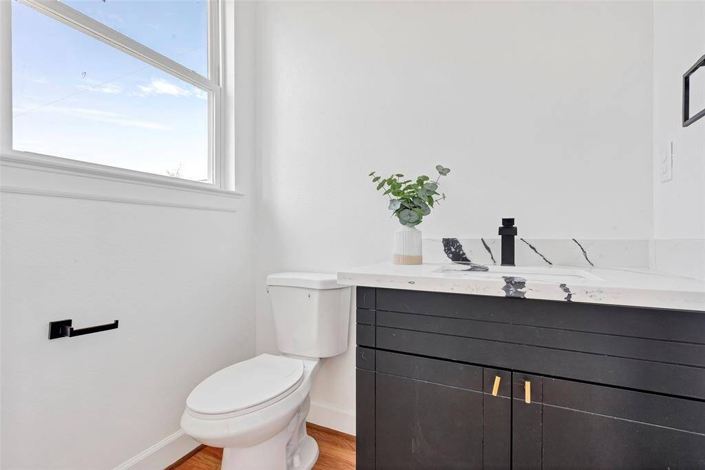 Take a closer look at the half bath, featuring a large glass window that brings in natural light. (Model unit at 1234 E 23rd St. Design and finishes may vary)