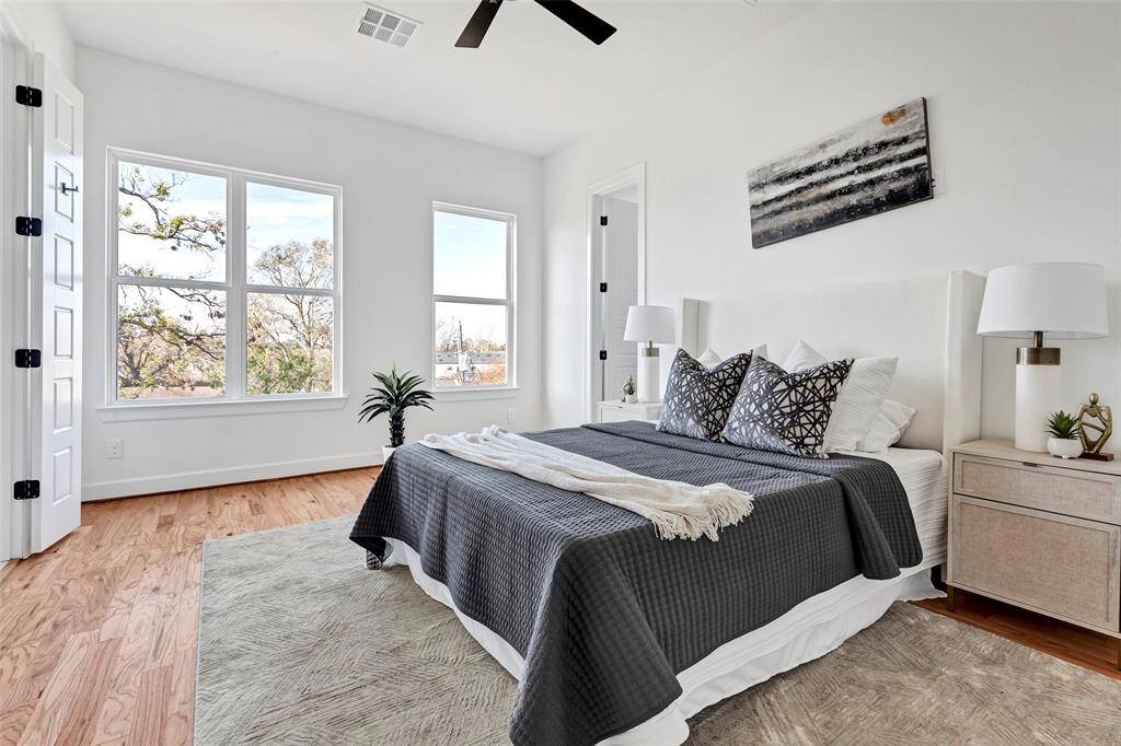 Welcome to the main bedroom, beautifully lit by large windows. (Model unit at 1234 E 23rd St. Design and finishes may vary)