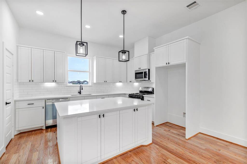 Welcome to this charming kitchen, featuring a functional kitchen island that adds both style and convenience to the space.