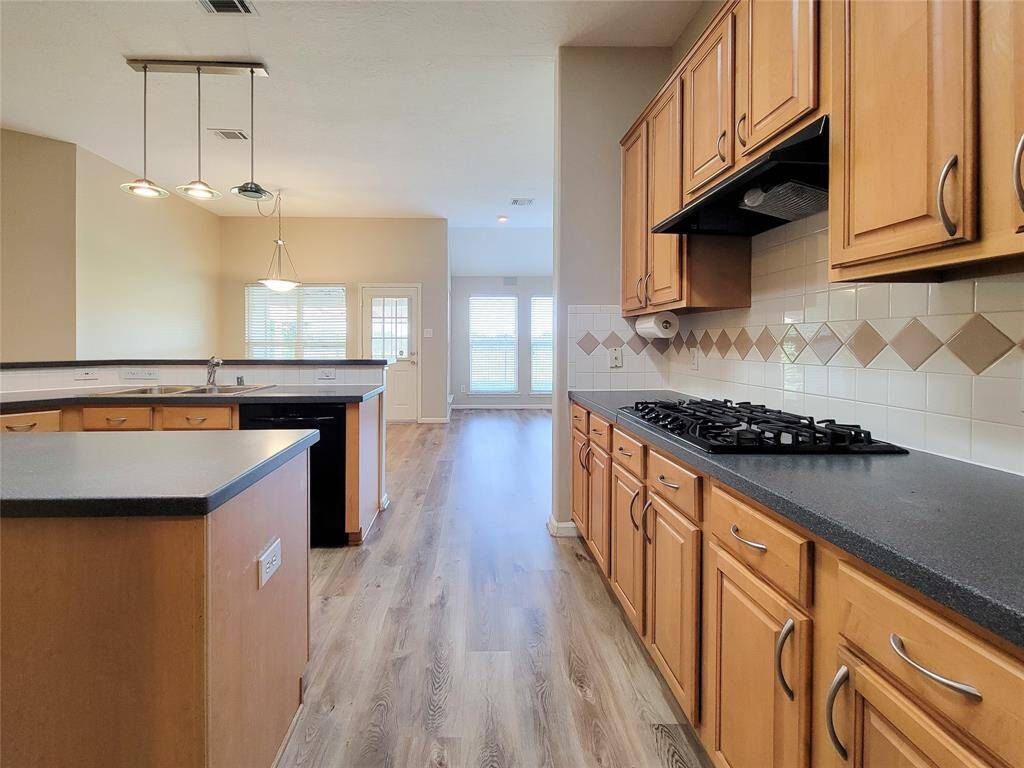 Pendent lights, black accent counters & Kitchen appliances.