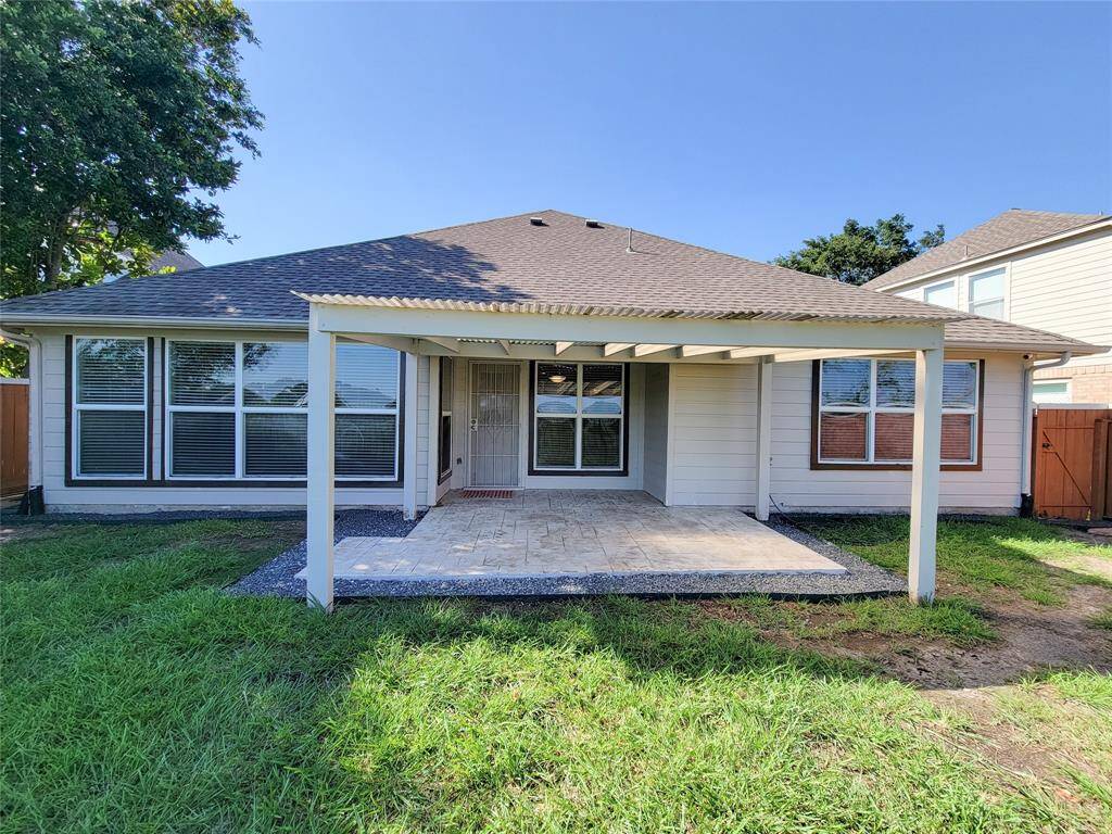 Relax in your Backyard. Covered patio recently updated with tile floor and pebble trimmed border (May 2024).