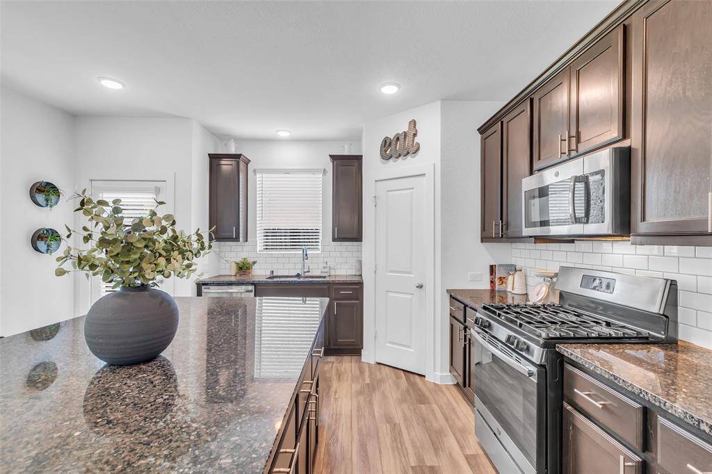This kitchen has ample cabinetry for storage, a walk-in pantry, and a gas stove for precision cooking.