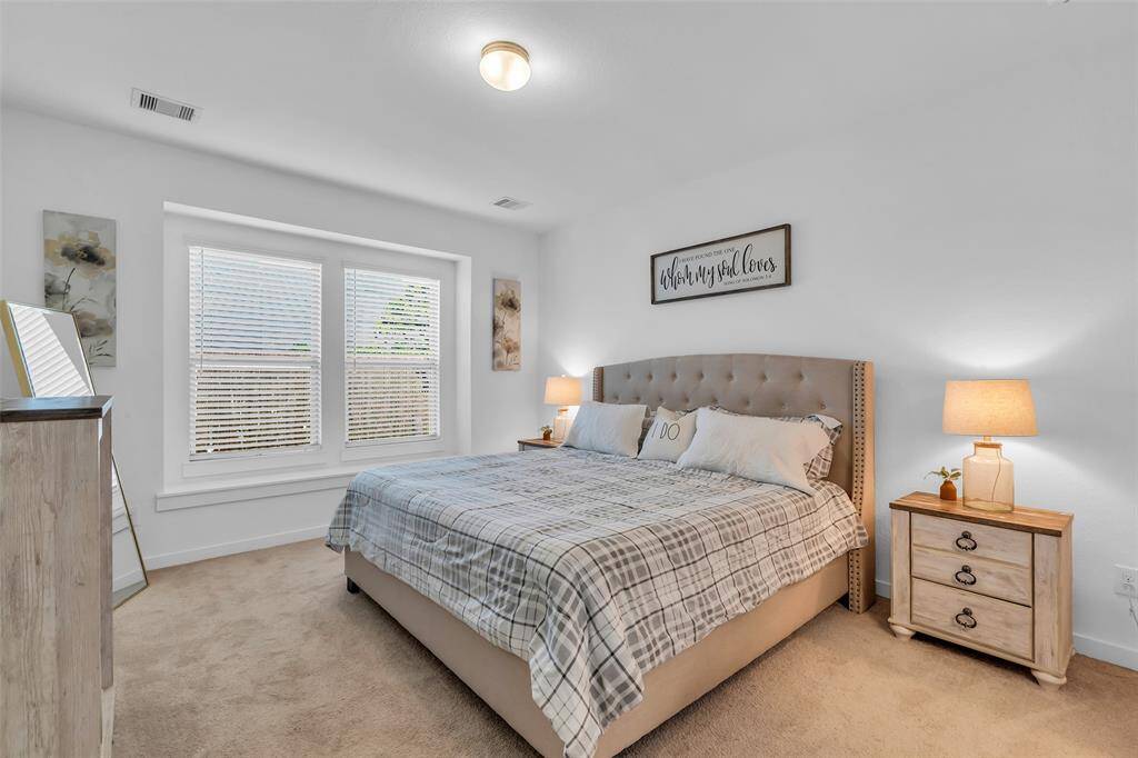 The spacious downstairs primary suite is filled with natural light and offers serene views of the backyard.