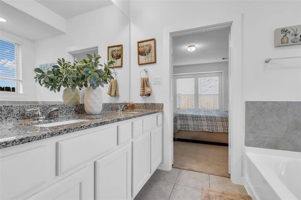 The double sink vanity is beautifully designed with ample counter space and elegant storage, making it both functional and stylish.