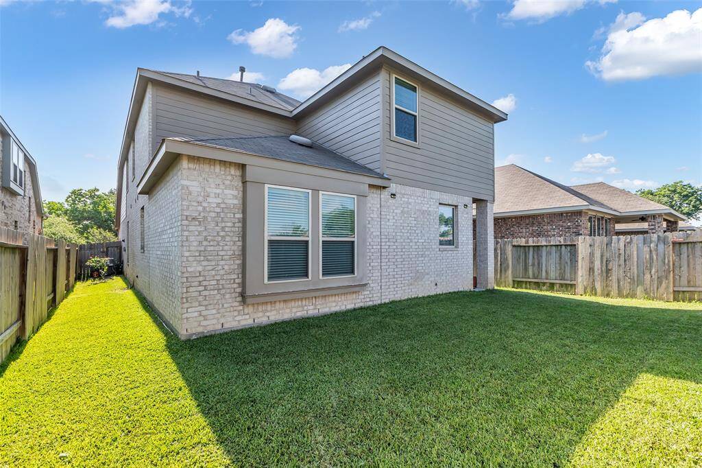 The yard is fully fenced and meticulously maintained, providing an ideal setting for summer backyard BBQs.