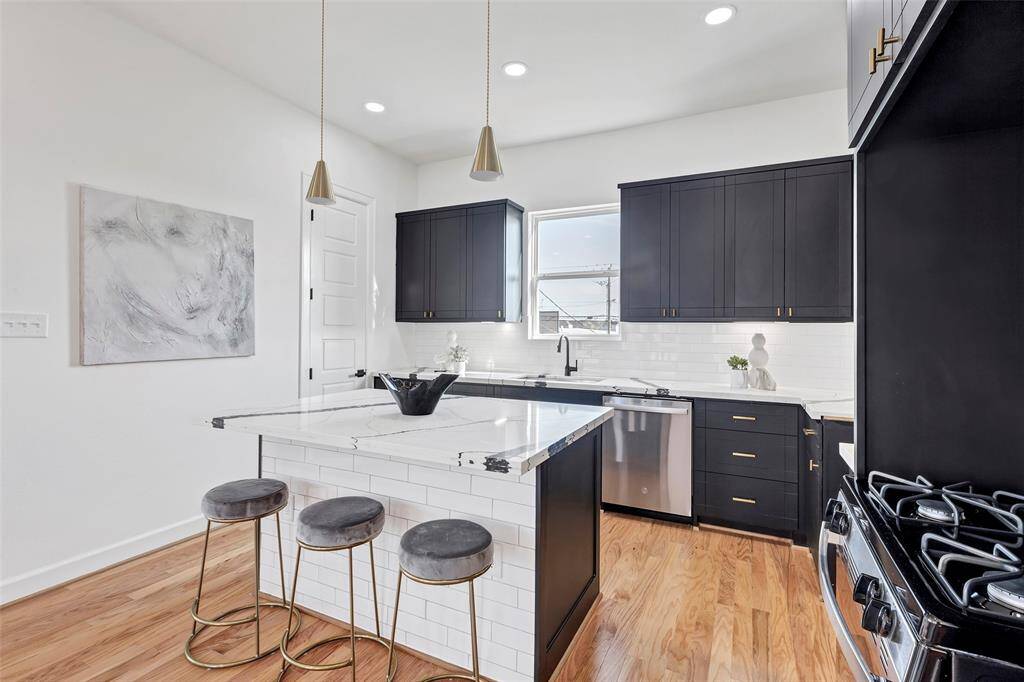 Complete with sleek stainless steel appliances and ample kitchen cabinets for storage, this space combines functionality with modern style.