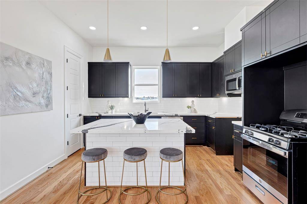 The rich dark cabinetry contrasts beautifully with the white walls and kitchen island, creating a stylish and visually pleasing atmosphere in this modern kitchen.