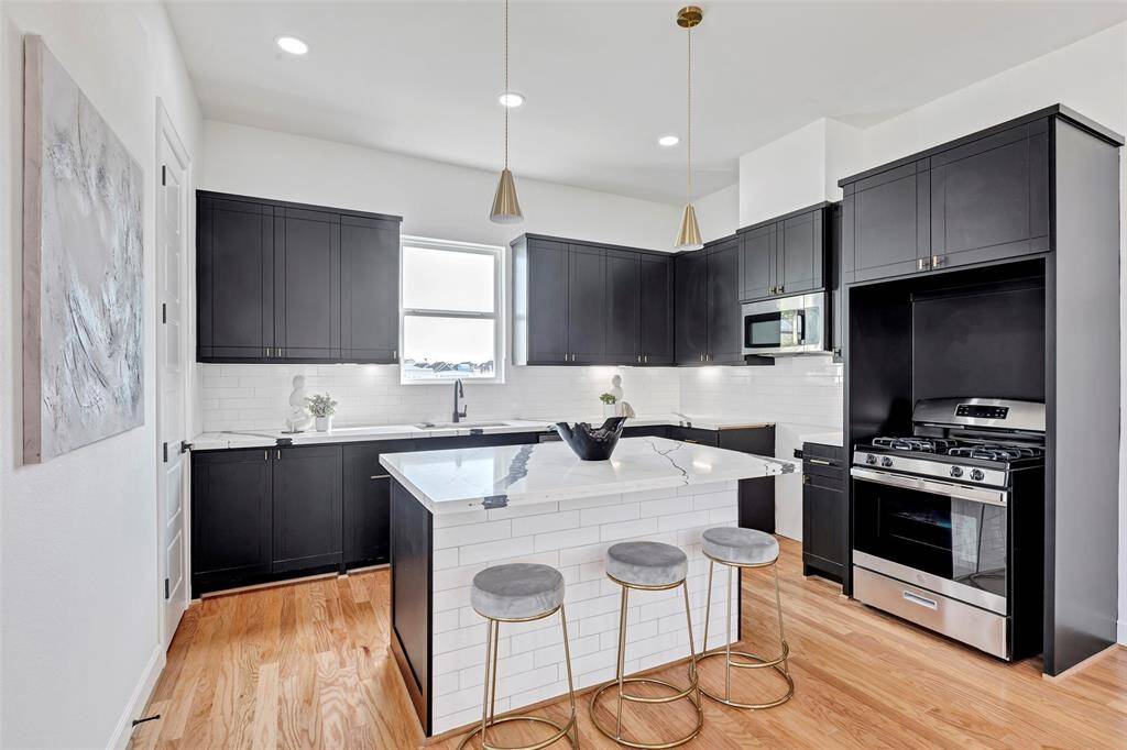 Welcome to this charming kitchen, featuring a functional kitchen island that adds both style and convenience to the space.
