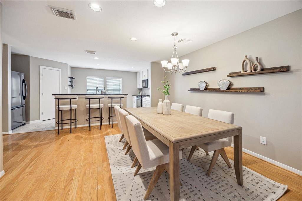 Your friends and family will love breaking bread with you in this open, elegant dining room with rich wood flooring, a stylish chandelier, and plenty of space for your dining table and sideboard.