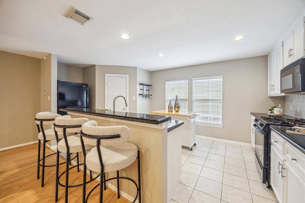 Ditch the takeout and cook from home more often. This fully loaded kitchen has granite countertops, sleek black appliances, crisp white cabinetry and a large pantry making meal prep and clean up a snap. As an added bonus, the refrigerator stays!