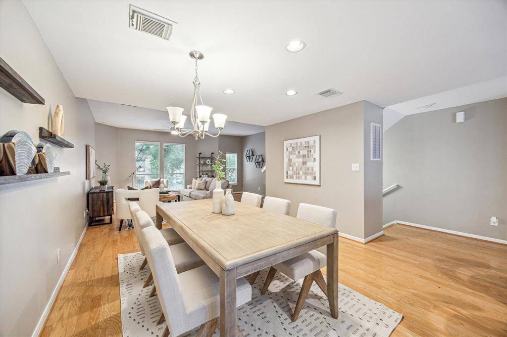 Gather them around your table to honor old traditions and create the new in this inviting open dining room, where warm wood flooring, soft neutral tones, and a chic chandelier set the stage for everything from casual gatherings to lavish dinner parties.