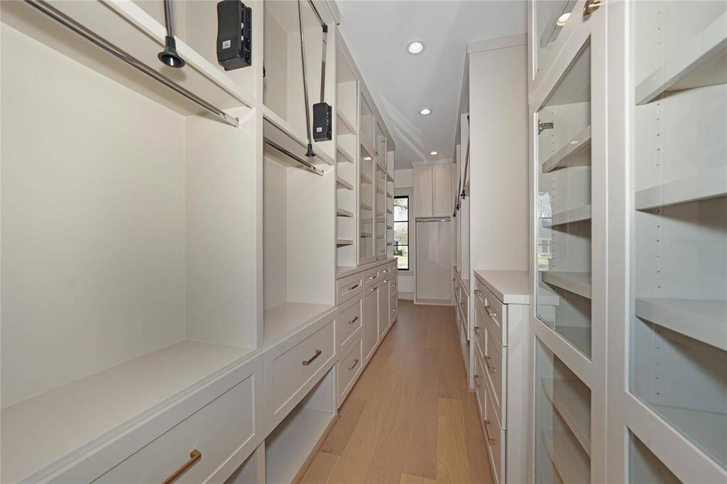 Enter into the Primary closet, complete with shelves, drawers, pull down hangers and space for all your closet needs