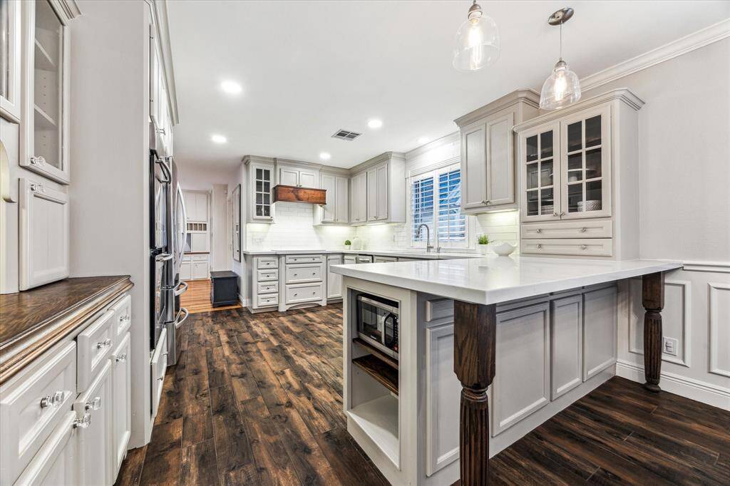 Updated with quartz countertops, flooring, custom walnut vent hood, modern backsplash and custom cabinetry.