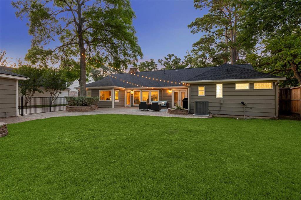 Expansive outdoor area with a stone-paved patio, offering plenty of room for entertaining, relaxing, gardening, or any outdoor activity.