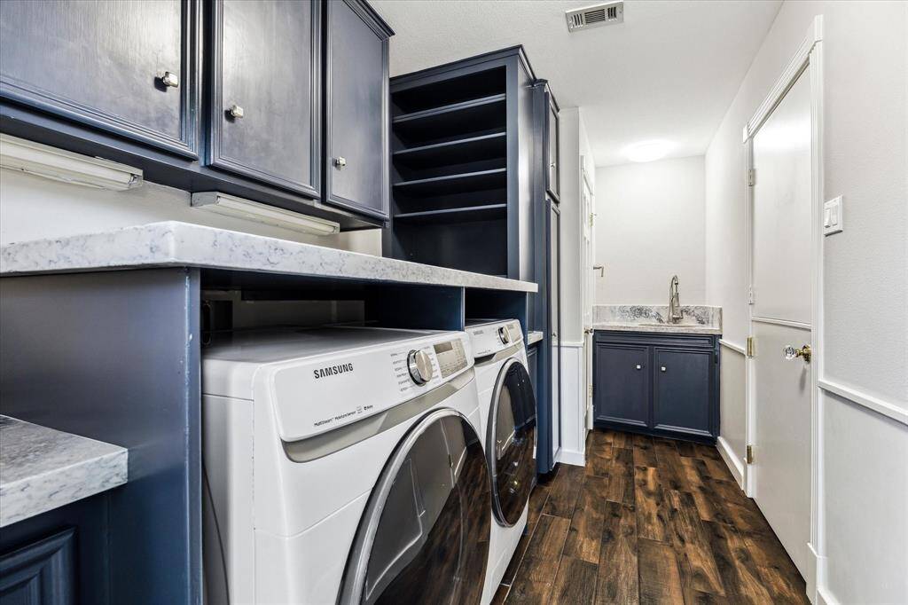 Laundry room with built-in cabinets and ample storage. Convenient powder room for guests.