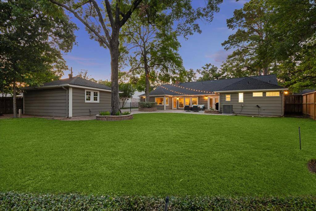 The spacious backyard features a stunning cobblestone paver patio, offering an ideal spot to enjoy outdoor living.