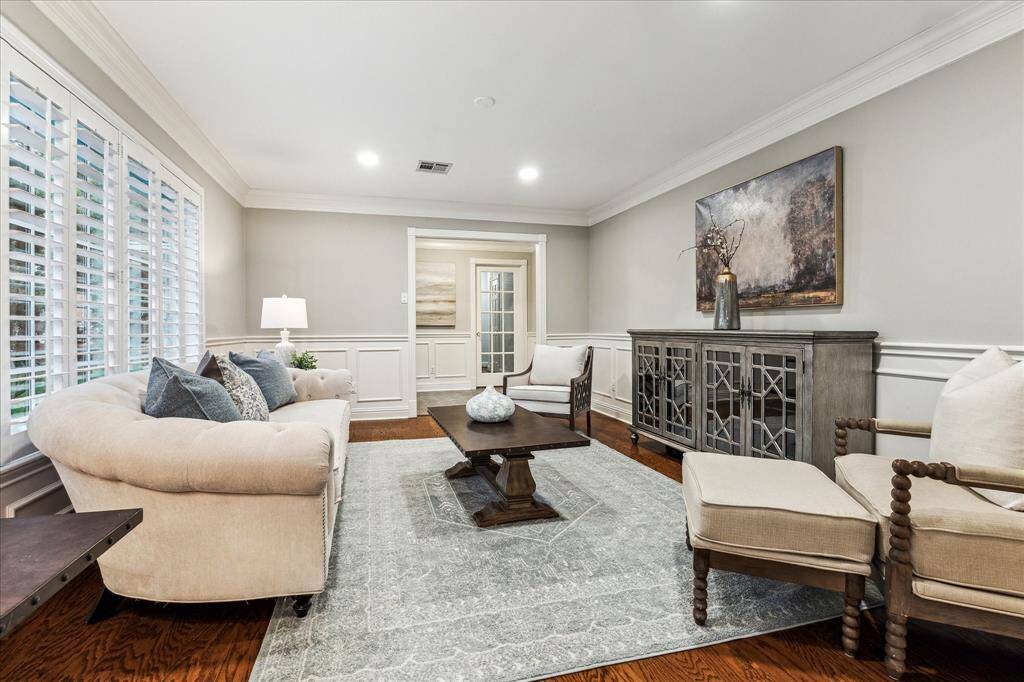 The formal living area features a spacious layout filled with natural light. Beautiful plantation shutters dress the windows, providing both privacy and style while enhancing the room’s warm, inviting ambiance.