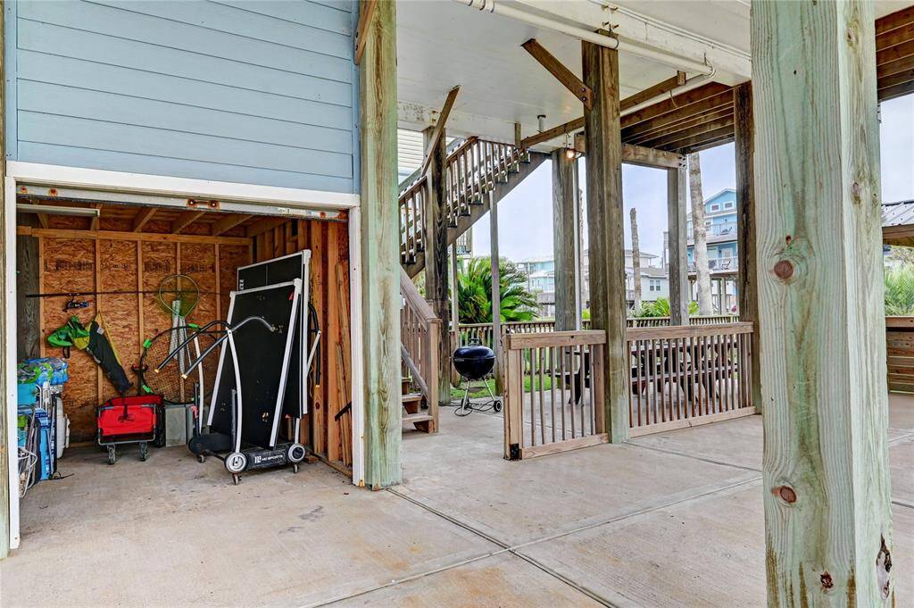 Storage room has a pedestrian door and an overhead door. It fits a golf cart, plus fishing and beach gear.