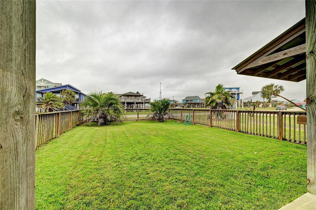 Fenced front yard with healthy grass.