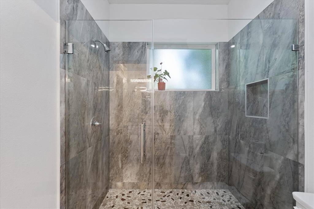 This second Full bathroom features this ample walk-in shower with custom tilework.