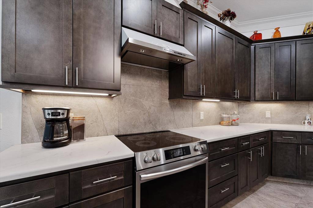 Quartz counters and backsplash compliment the wood cabinets
