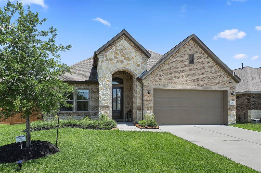 This charming home features a brick and stone exterior, well-maintained landscaping, and a two-car garage.