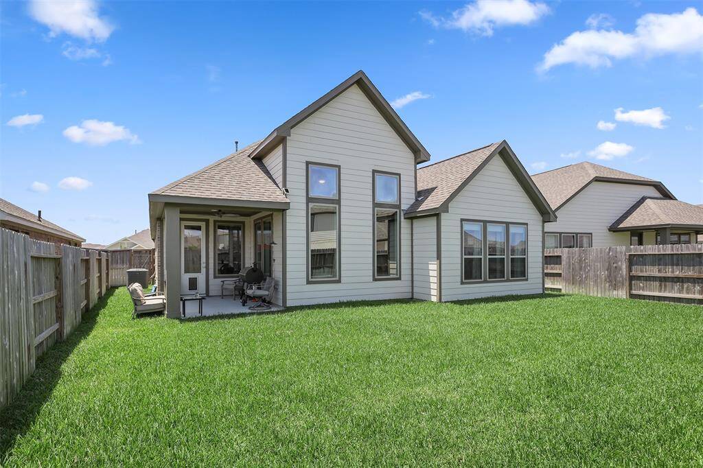 Charming home with a well-maintained backyard, featuring a covered patio area perfect for outdoor relaxation.