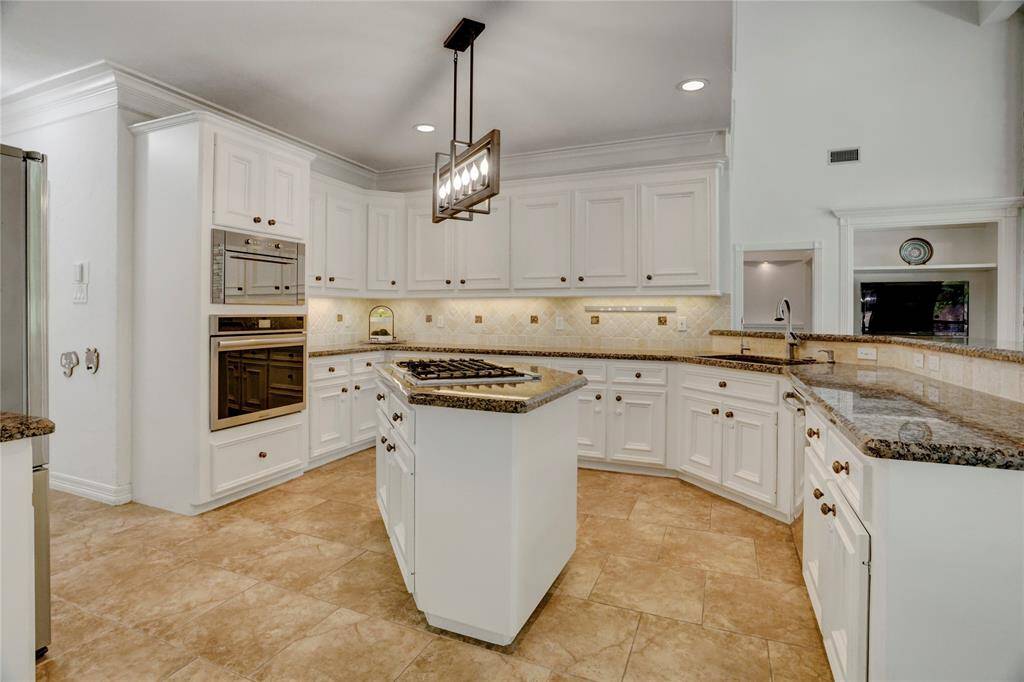 This kitchen features elegant undercabinet and recessed lighting, along with generous cabinet space.