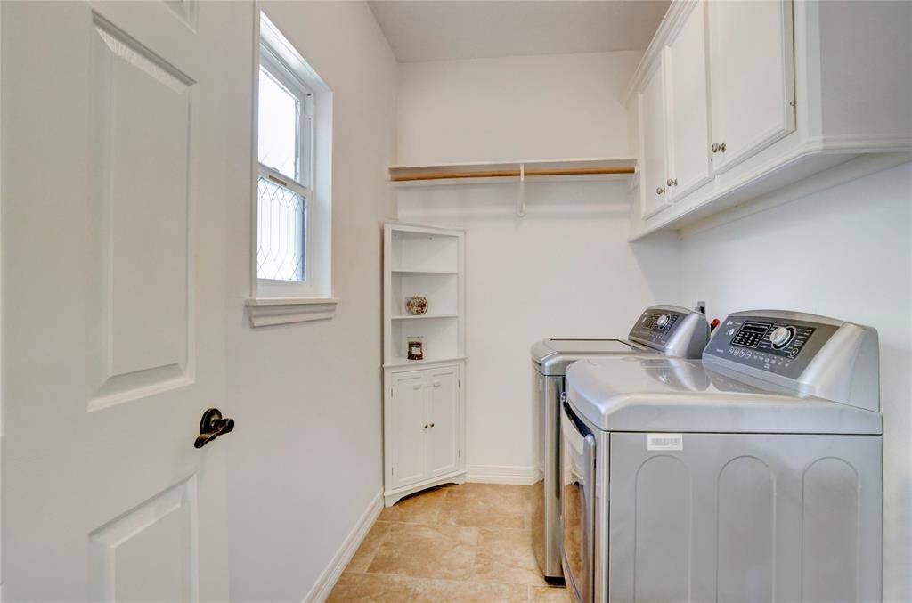 Spacious laundry room equipped with washer and dryer included.