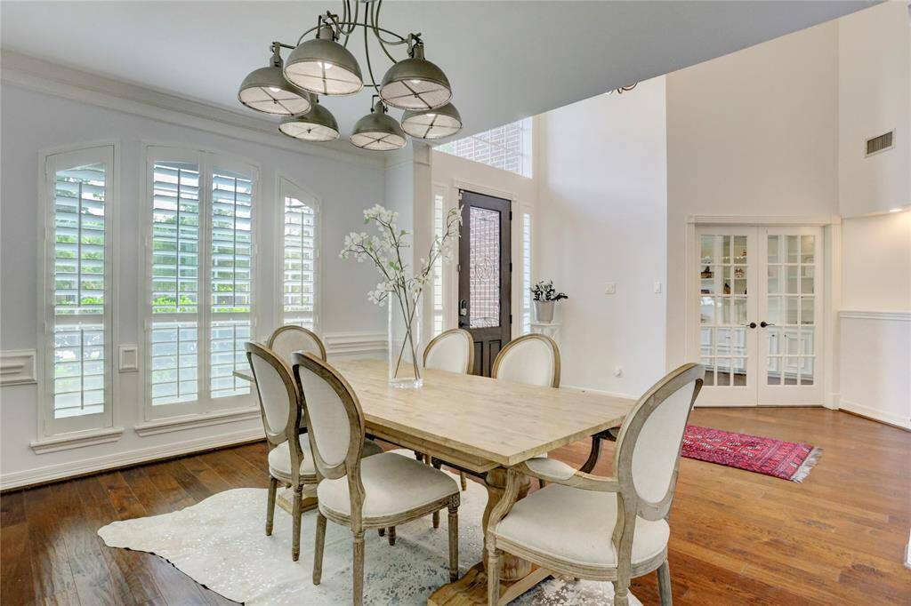 The foyers has the dining room on one side that features windows with plantation shutters, french doors that lead to the large office