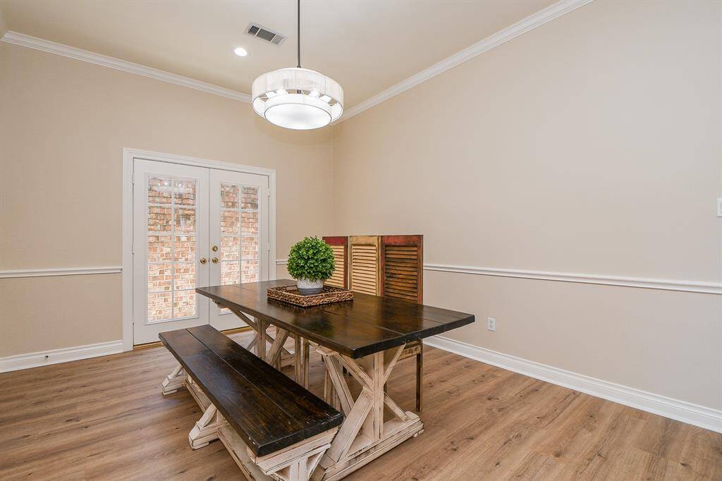 Large formal dining with double glass doors to precious bricked atrium.