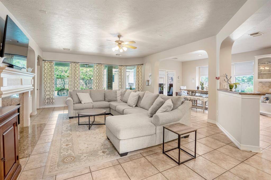 A wall of windows with views of the gorgeous backyard just beyond the living room area are a focal point of the room.