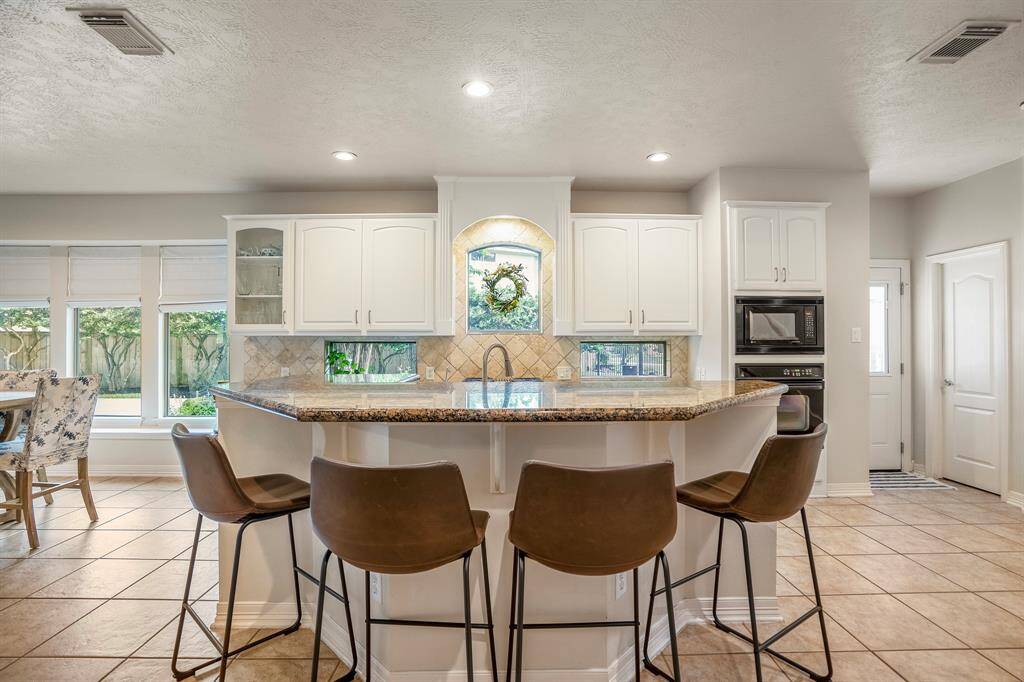 Spacious island kitchen & breakfast bar, 4 burner gas range, whole house water softener & reverse  osmosis water filter system at sink.