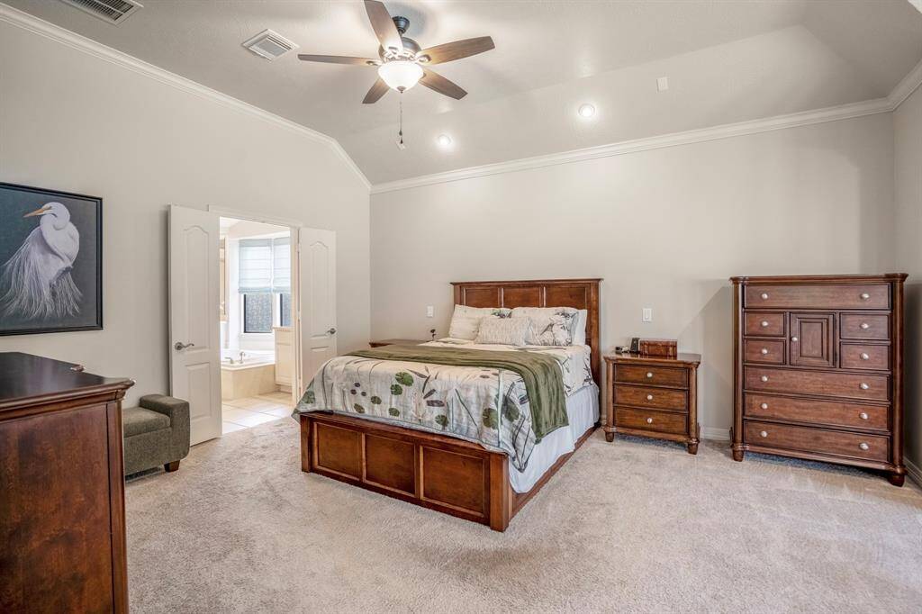 The primary bedroom has an spa like en-suite bathroom that is accessed through double doors.  Notice the crown molding on the ceiling line.