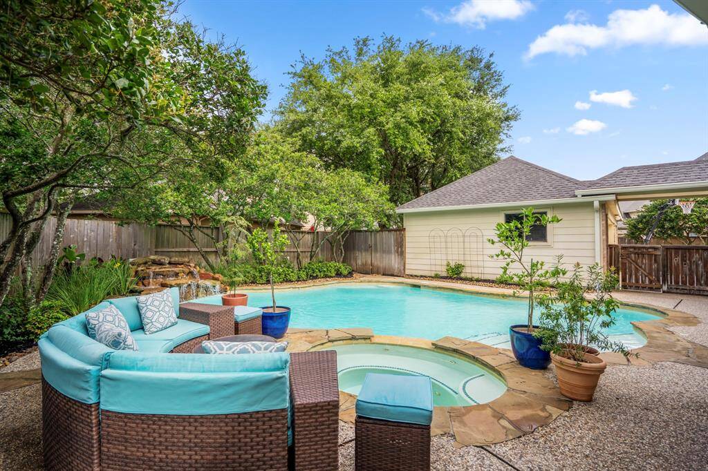 The private backyard offers lots of established landscaping, a sparkling pool and spa as well as a calming rock waterfall for ambiance.