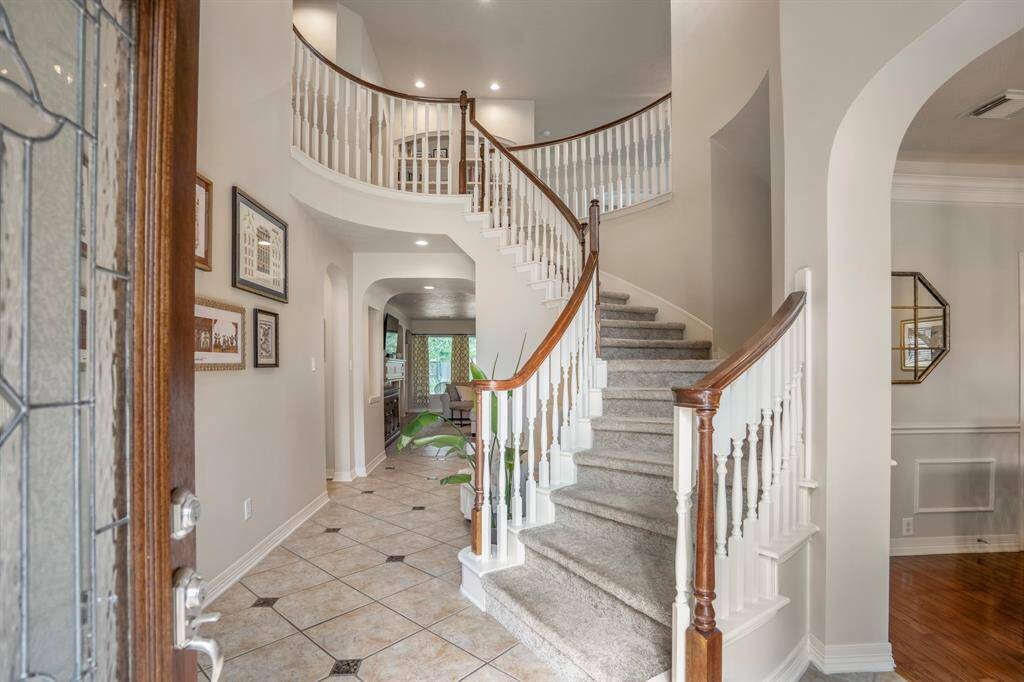 A light reflecting glass lead and wood surrounding door leads into your new home with spiral staircase leading upstairs.