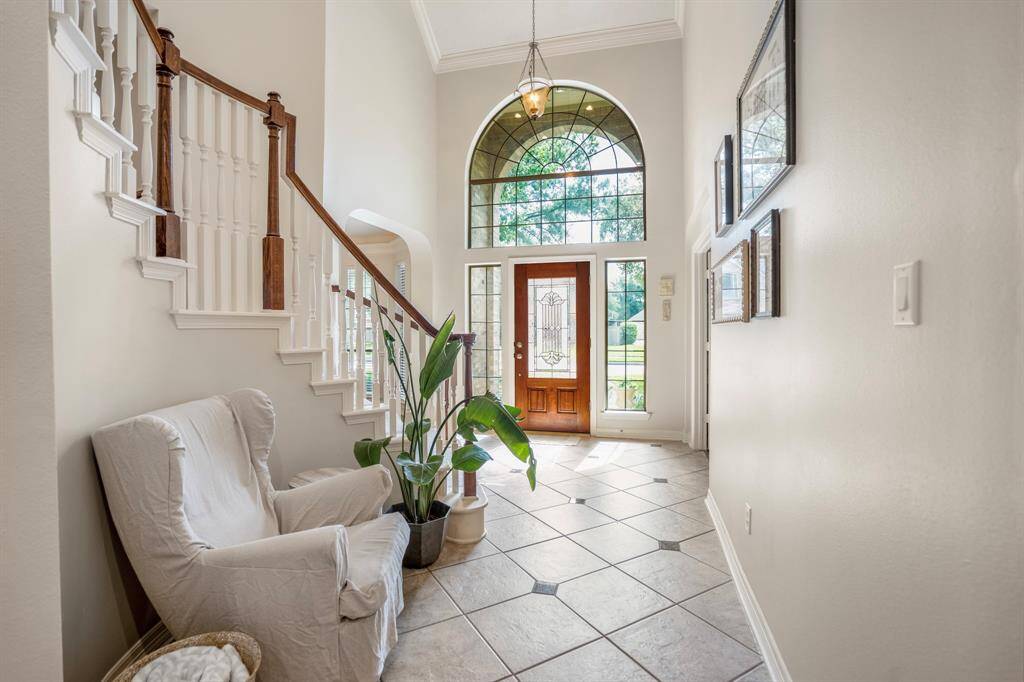 The two-story entry has ample space to receive friends and family, with light reflecting through expansive windows above and next to the entry door.
