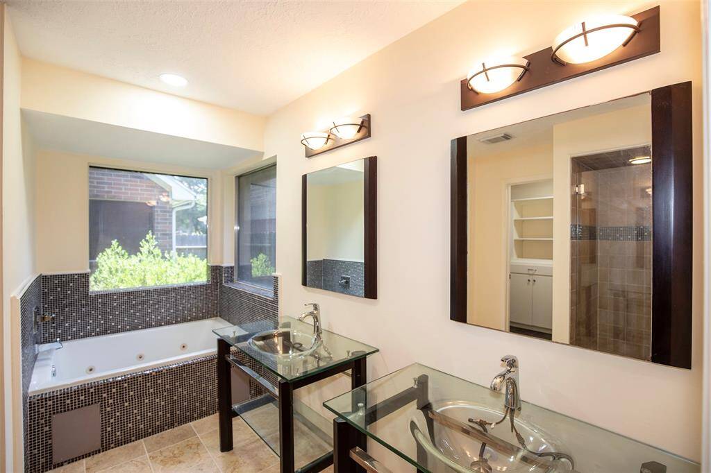 The primary bathroom boasts double sinks and updated lighting.