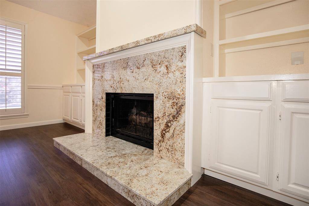 The fireplace serves as a striking focal point, featuring a sleek granite hearth and face that add a touch of sophistication to the room.