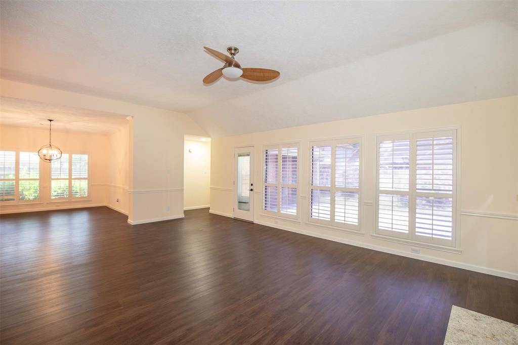 A wall of windows allows natural light to pour in, creating a bright and airy atmosphere, while plantation shutters offer both charm and privacy.