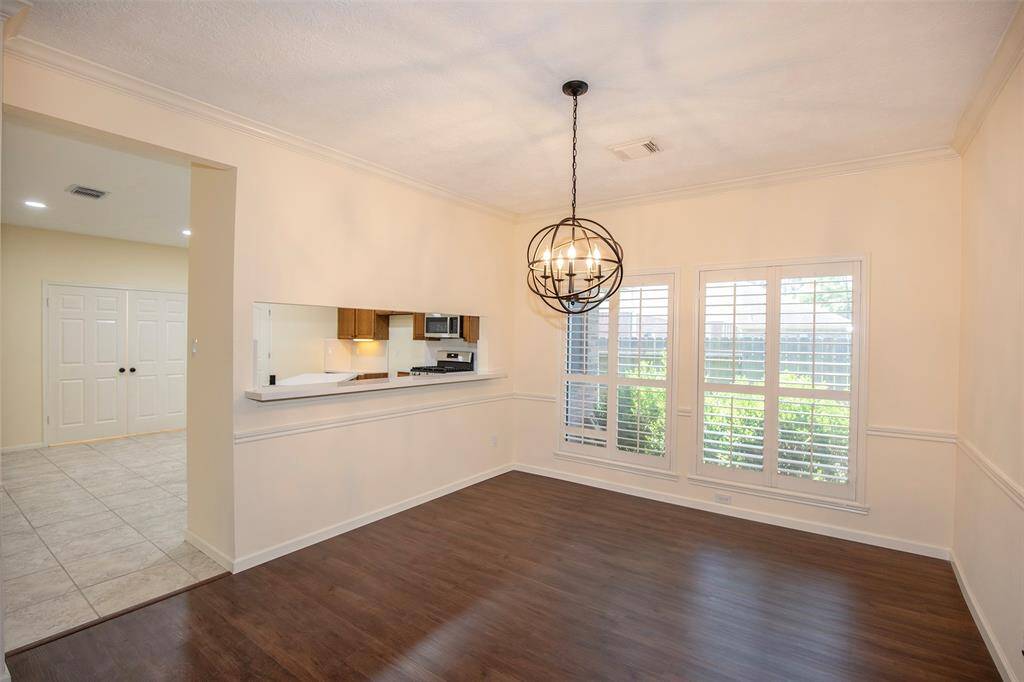 Spacious formal dining room features plantation shutters and beautiful lighting.