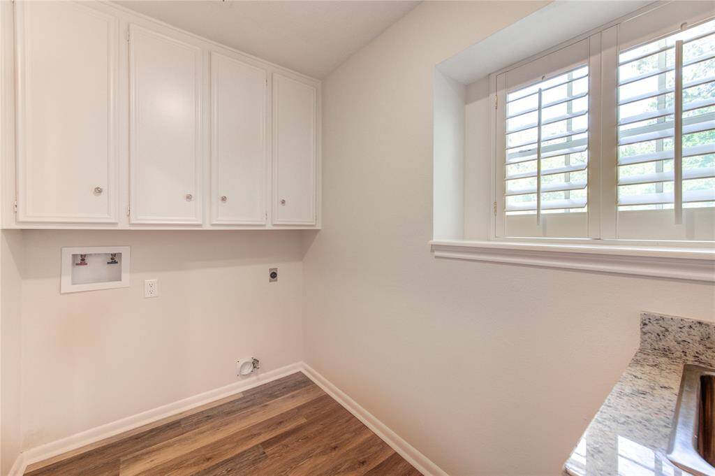 Large laundry room with storage cabinets, gas and electric connections and a utility sink.  All windows along the front of the house have plantation shutters too.
