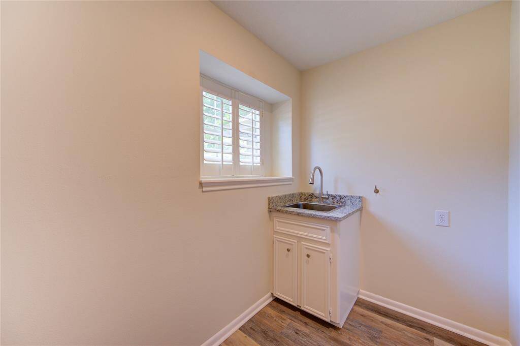 Utility sink in laundry room with new granite and faucet.  There is a space to the right to the sink for a secondary refrigerator.