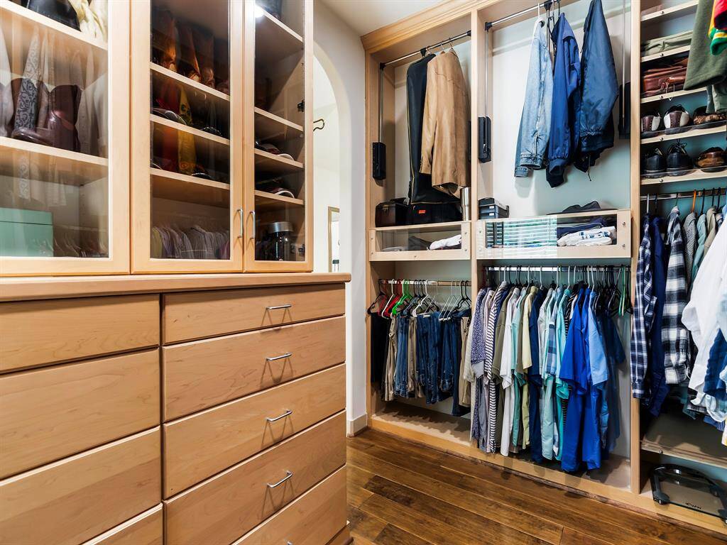 The custom closet is thoughtfully designed to keep everything organized with enclosed storage drawers, cabinets and smart built-ins throughout.