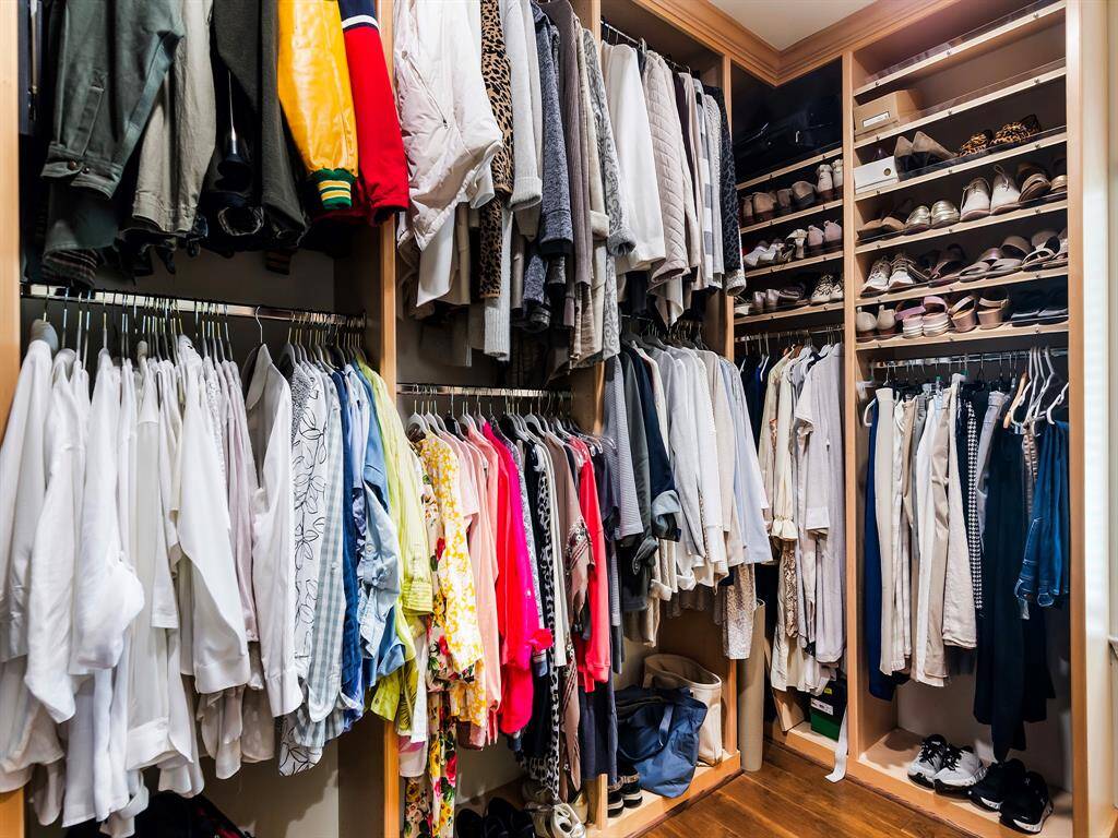 This photo showcases a spacious, well-organized walk-in closet with ample shelving and hanging space, ideal for storing clothing and shoes efficiently.