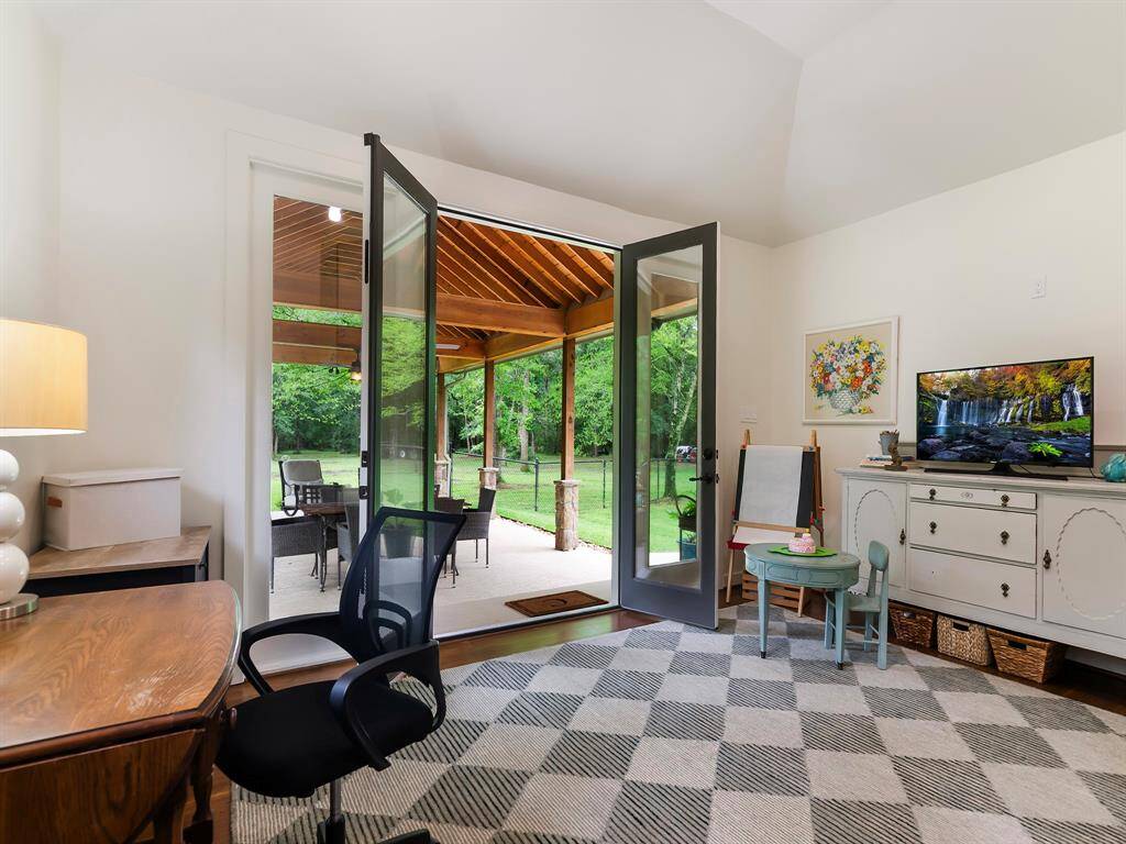 This flexible home office features double doors that open to the covered pavilion with peaceful views of the surrounding acreage. Whether used as a home office, hobby room, library, game room or workout studio it adapts beautifully to your needs.