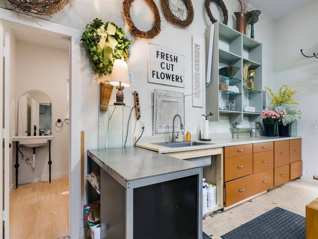 This picture frame highlights a portion of the 30'x30' workshop currently used as a floral hobby space, featuring upper shelves, lower storage cabinets and a convenient sink. It's ideal for creative projects.