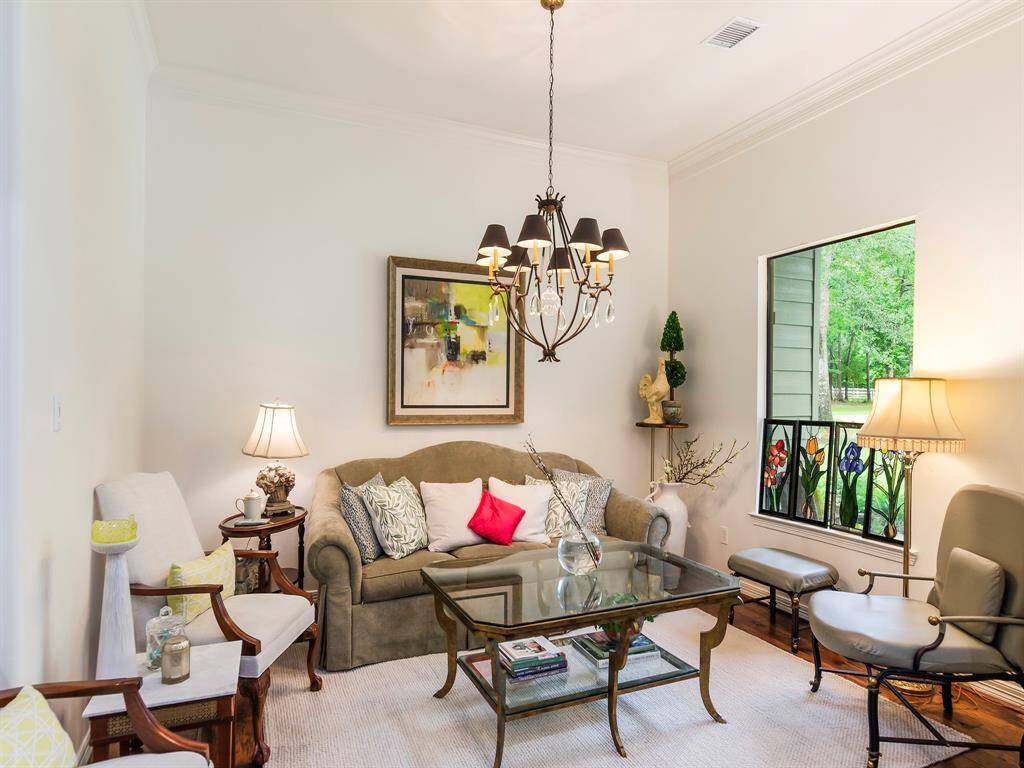 A graceful formal living room invites relaxed conversation, framed by a picture window with a peaceful view of the front grounds.
